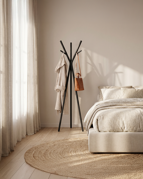 modern multipurpose cloths rack standing in a stylish bedroom with a robe and bag hanging.